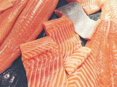 Çiğ somon dilimlenmiş veya taze somon. Somon fileto bir patchwork etkisi ile görüntülenen pazarında Satılık. Satılık süpermarket olan et dilimleri içinde siyah bir tepsi birçok taze somon balık.