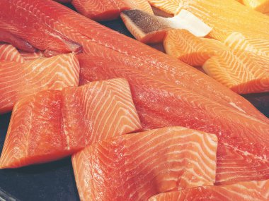Çiğ somon dilimlenmiş veya taze somon. Somon fileto bir patchwork etkisi ile görüntülenen pazarında Satılık. Satılık süpermarket olan et dilimleri içinde siyah bir tepsi birçok taze somon balık.