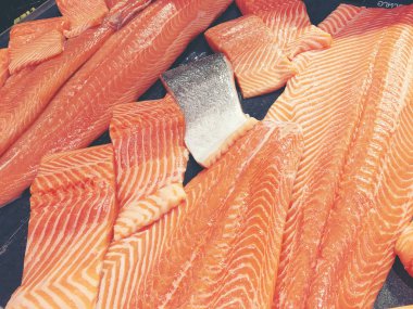 Çiğ somon dilimlenmiş veya taze somon. Somon fileto bir patchwork etkisi ile görüntülenen pazarında Satılık. Satılık süpermarket olan et dilimleri içinde siyah bir tepsi birçok taze somon balık.