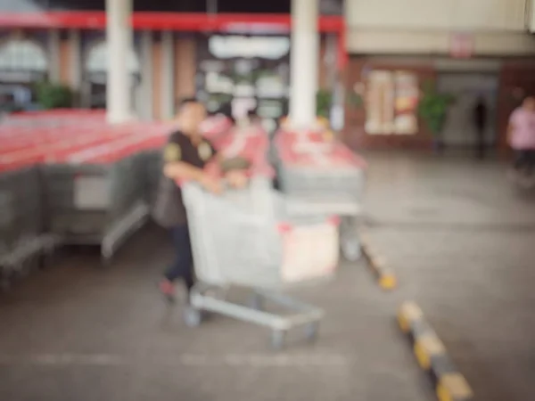 Blurred image of people shopping in at hardware store or storehouse with variety of indoor & outdoor ceiling fans, flushmount,recessed,track lights, led. vintage tone with light effect. — Stock Photo, Image