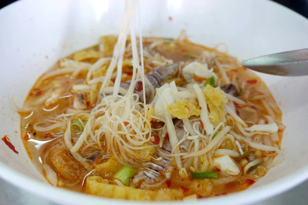辛辣的海鲜面条汤 配小龙虾 虾和蘑菇 亚洲食物在白色碗在桌上背景 泰国风格的面条和泰国的街头食品 — 图库照片
