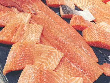 Çiğ somon dilimlenmiş veya taze somon. Somon fileto bir patchwork etkisi ile görüntülenen pazarında Satılık. Satılık süpermarket olan et dilimleri içinde siyah bir tepsi birçok taze somon balık.