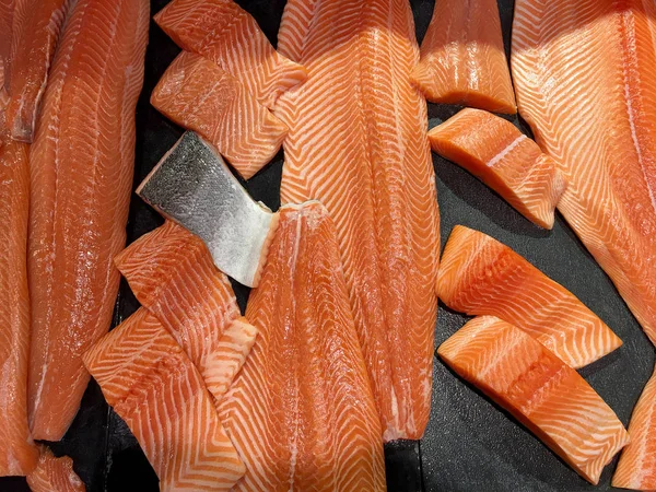 Çiğ somon dilimlenmiş veya taze somon. Somon fileto bir patchwork etkisi ile görüntülenen pazarında Satılık. Satılık süpermarket olan et dilimleri içinde siyah bir tepsi birçok taze somon balık.