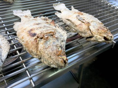 Tuz ve ocakta içinde bitki ile kırmızı tilapia yemek ızgara. Tayland yerel yemekleri tuzlu balık, Tay street gıda pazarında popüler bir yemek ızgara