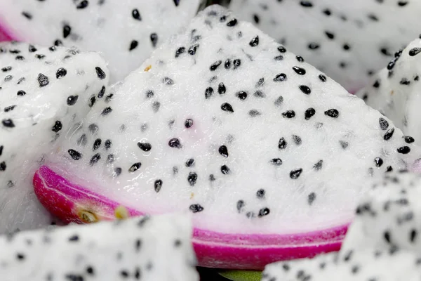 Healthy dragon fruit or pitaya pieces background, close up of beautiful fresh sliced dragon fruit with texture in the market in thailand. Pitaya is the plant in Cactaceae family or Cactus.