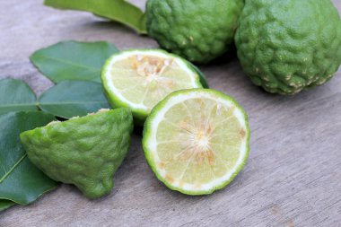 Tahta masa arkasında taze Bergamot meyvesi ve bergamot yaprakları grubu