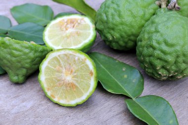 Tahta masa arkasında taze Bergamot meyvesi ve bergamot yaprakları grubu