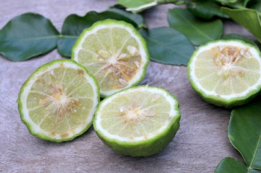 Tahta masa arkasında taze Bergamot meyvesi ve bergamot yaprakları grubu