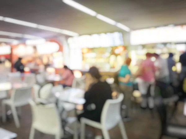 Abstract blur image of people are waiting, queuing for order some food in food court store, and make payment in Fastfood Store. vintage tone and light effect.enjoy eating with their family.