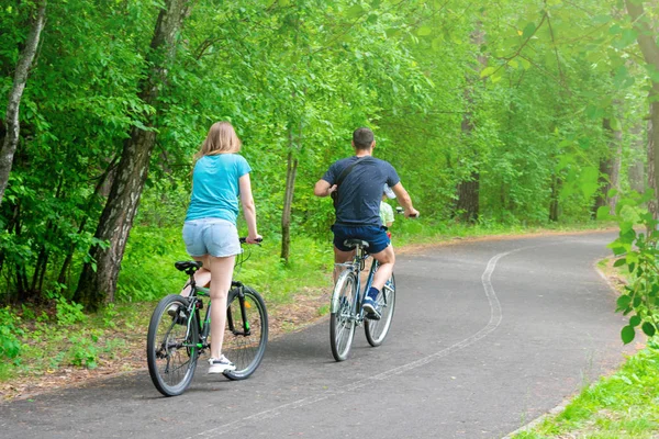 Family bike ride in the park. City park with cycle path.