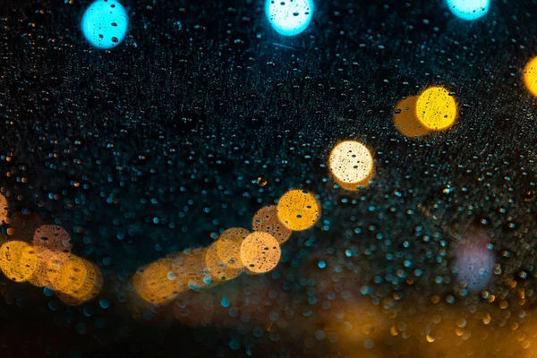 Farolas a través del parabrisas con gotas de lluvia —  Fotos de Stock