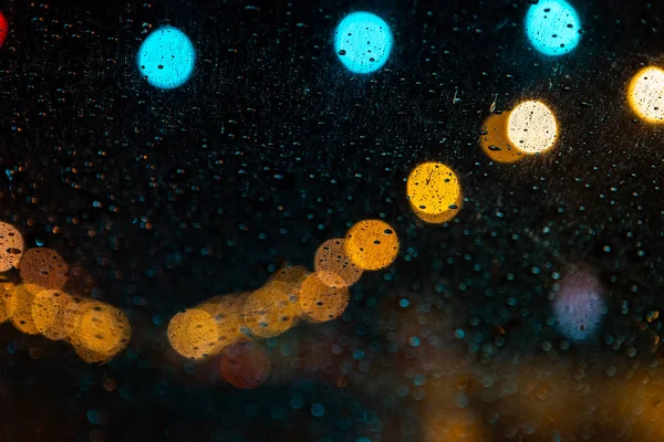 Farolas a través del parabrisas con gotas de lluvia —  Fotos de Stock
