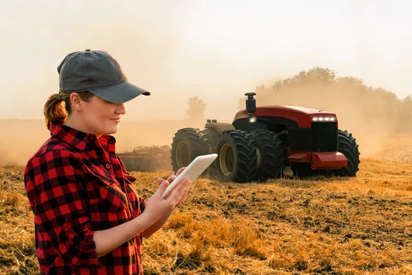 디지털 태블릿을 가지고 농부가 농장에서 트랙터를 조종한다 — 스톡 사진
