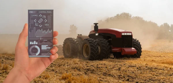 Farmer controls an autonomous tractor