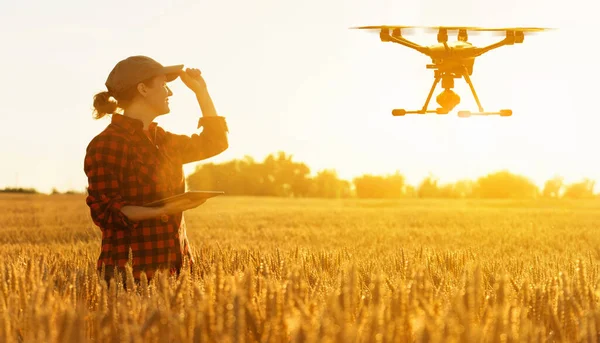 Woman farmer controls drone with a tablet