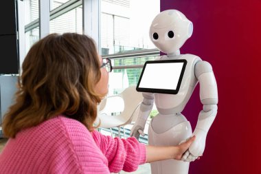 A woman communicates with a robot consultant clipart