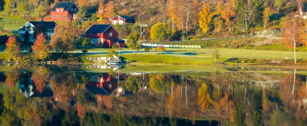湖边的村庄 秋天的森林和房屋反映在水中 — 图库照片