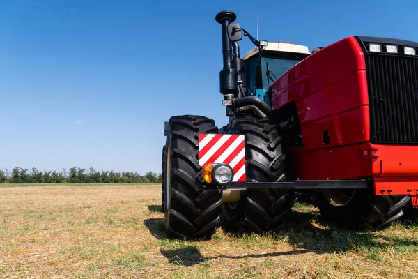 Красный трактор на поле — стоковое фото