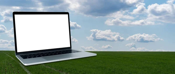 Ordinateur portable avec écran blanc sur un fond de champ agricole — Photo