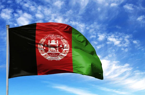 National flag of Afghanistan on a flagpole in front of blue sky