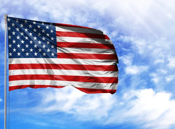 National flag of America on a flagpole in front of blue sky