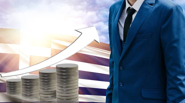 Business concept of increasing sales, Businessman on the background of the flag of Greece and a graph of increasing up.