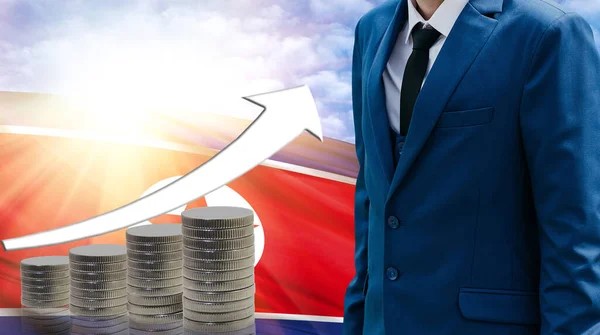 Business concept of increasing sales, Businessman on the background of the flag of North Korea and a graph of increasing up.