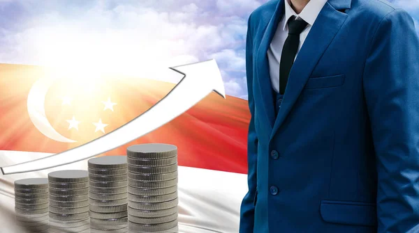 Business concept of increasing sales, Businessman on the background of the flag of Singapore and a graph of increasing up.