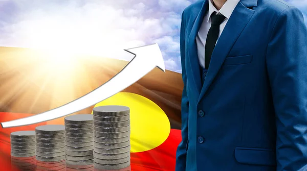 Business concept of increasing sales, Businessman on the background of the flag of Australian Aboriginal and a graph of increasing up.