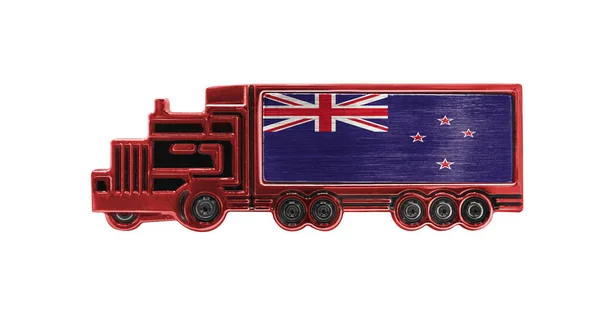 Toy truck with New Zealand flag shown isolated on white background. The concept of cargo transportation between countries.