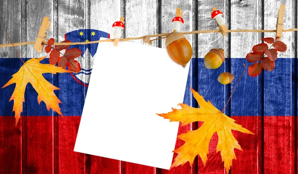 Slovenia flag on autumn wooden background with leaves and good place for your text.