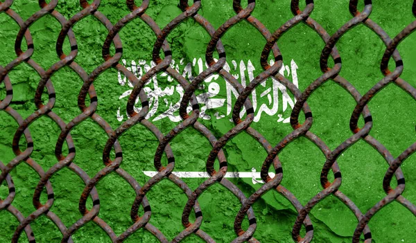 Immigration policy regarding migrants, illegal immigrants and refugees. Steel grid on the background of the flag of Saudi Arabia