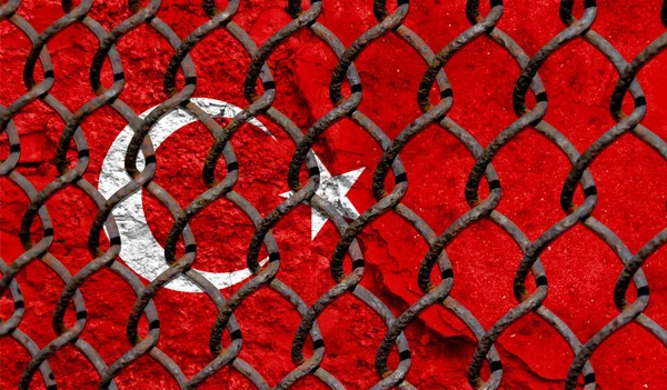 Immigration policy regarding migrants, illegal immigrants and refugees. Steel grid on the background of the flag of Turkey