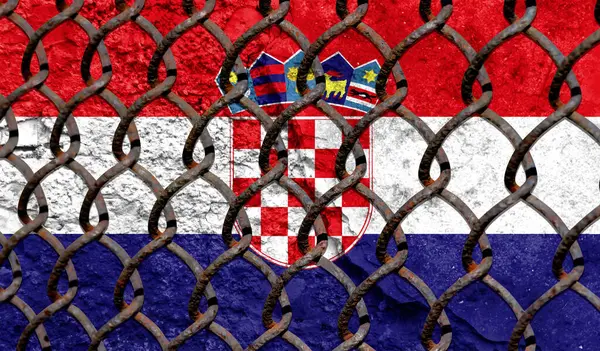 Immigration policy regarding migrants, illegal immigrants and refugees. Steel grid on the background of the flag of Croatia