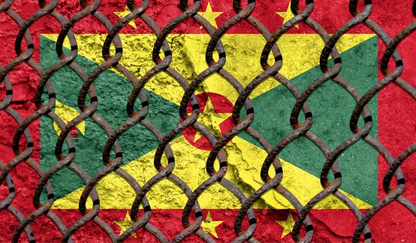 Immigration policy regarding migrants, illegal immigrants and refugees. Steel grid on the background of the flag of Grenada
