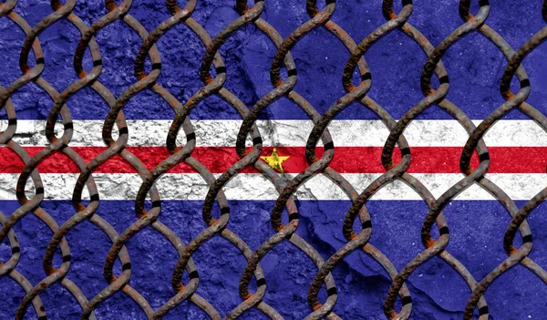 Immigration policy regarding migrants, illegal immigrants and refugees. Steel grid on the background of the flag of Cape verde