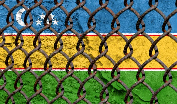 Immigration policy regarding migrants, illegal immigrants and refugees. Steel grid on the background of the flag of Karakalpakstan