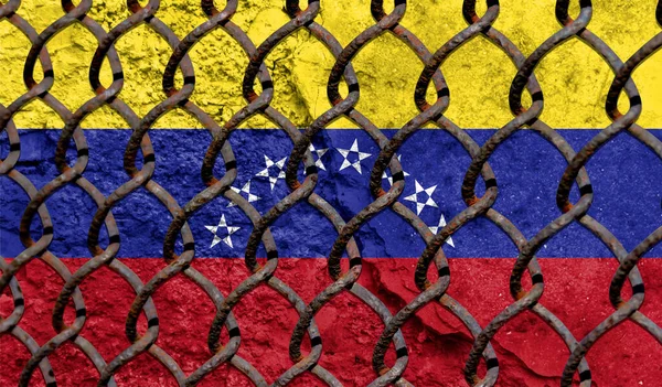 Immigration policy regarding migrants, illegal immigrants and refugees. Steel grid on the background of the flag of Venezuela