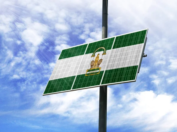 Solar panels against a blue sky with a picture of the flag of Andalusia