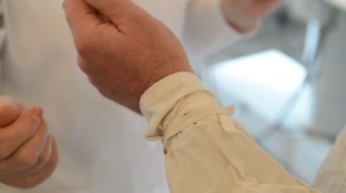 Hemşire yardım için hastanede ameliyata hazırlama önünde onu soyunma tarafından doktordur