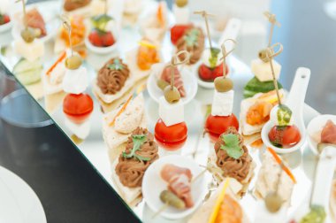 Atıştırmalıklar, balık ve et spesiyalleri büfe üzerinde.