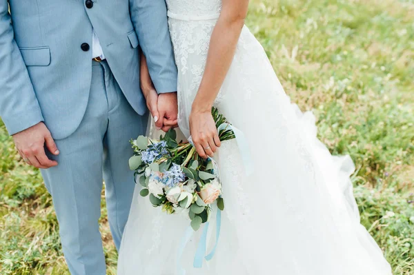 Sposa in un vestito che tiene un mazzo nuziale — Foto Stock