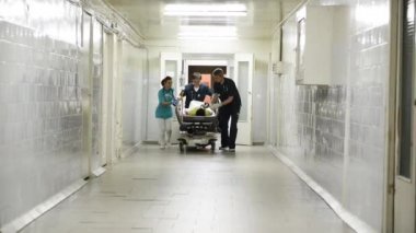 Acil durum bölümü: Doktorlar, hemşireler ve cerrahlar ağır yaralı hasta taşıma.