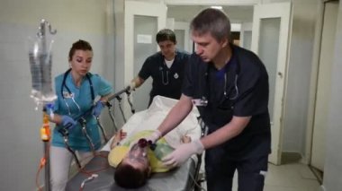 Acil durum bölümü: Doktorlar, hemşireler ve cerrahlar ağır yaralı hasta taşıma.