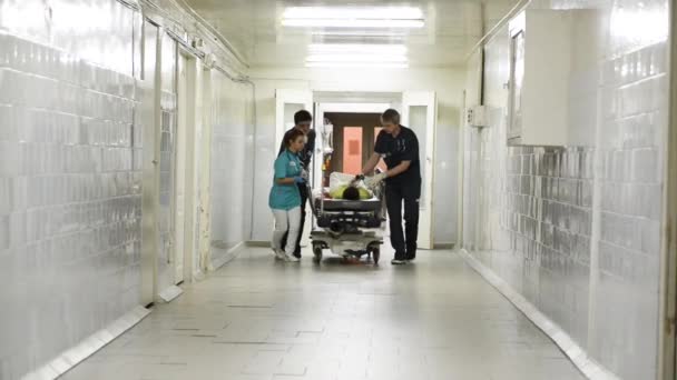 Отделение неотложной помощи: врачи, медсестры и хирурги перемещают тяжело раненого пациента . — стоковое видео