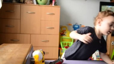 küçük çocuk çocuk odasında oyuncak araba ile oynarken