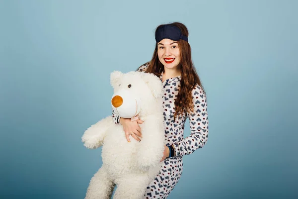 Krásná mladá žena nosí pyžamo objímání její plyšová medvídek — Stock fotografie