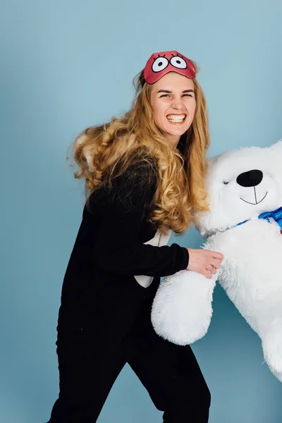 A beautiful young woman wearing pajamas hugging her stuffed teddy bear — Stock Photo, Image