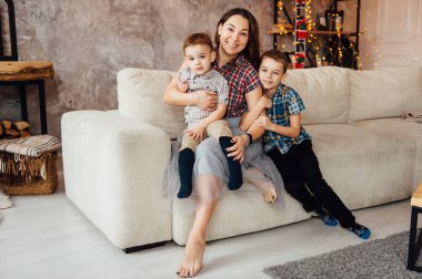 güzel anne kanepede onu iki oğlu kucaklıyor