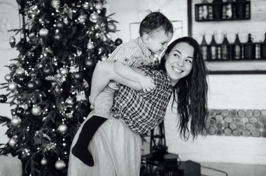 güzel anne xmas ağacının yanındaki kanepede oğlunu kucaklıyor